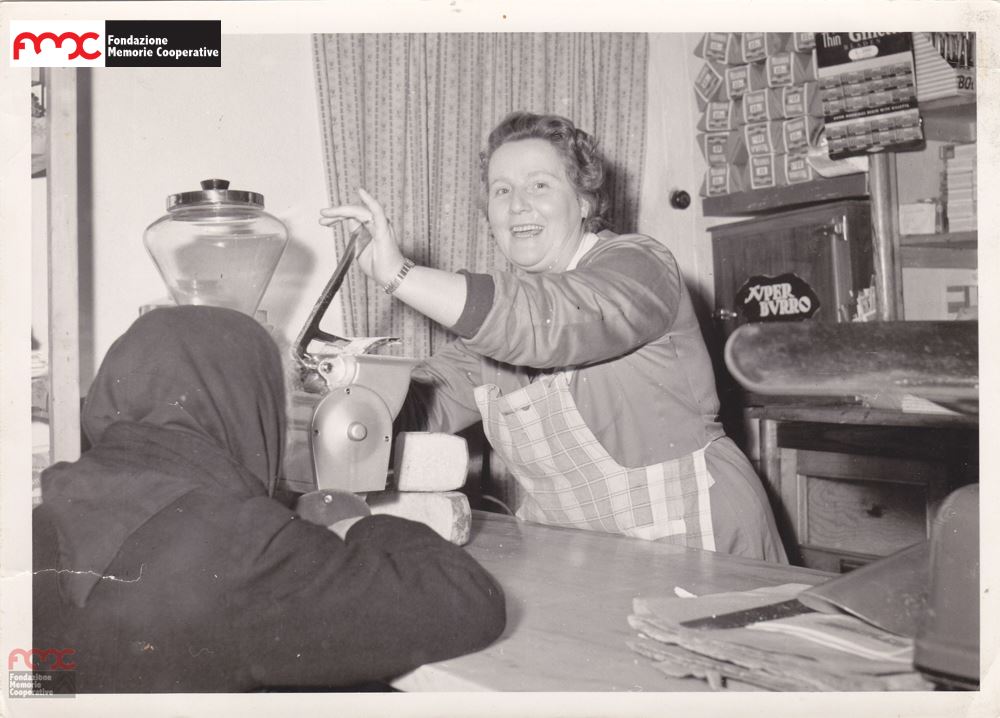 Foto 5. Primo piano di una dipendente di uno spaccio cooperativo, fine  anni '50