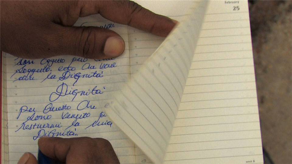Foto1 Zakaria Mohamed Ali, Scrittura sul molo di Lampedusa per il corto To whom it may concern, Lampedusa 2012 (©Zakaria Mohamed Ali)