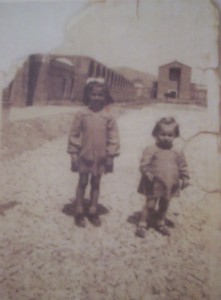 Foto 2. Due giovanissime profughe appena giunte a Fertilia nel 1949 (sullo sfondo si noti la desolazione dell’abitato), in Ame.